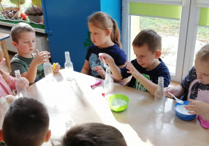 Dzieci sypią sodę do butelek